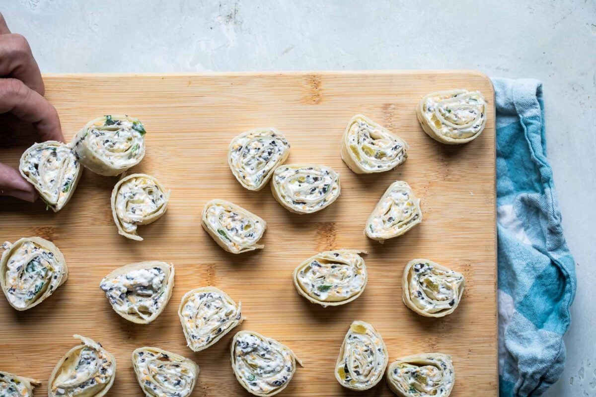 Slices of Mexican tortilla roll ups on a board.