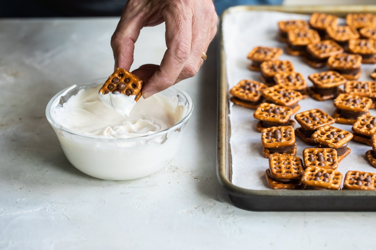 Dipping Rolo pretzel candies in chocolate.