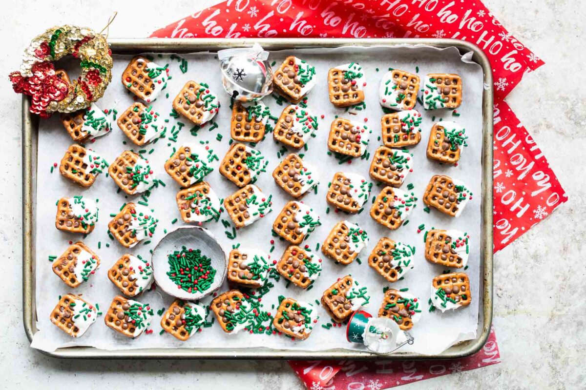Rolo pretzel candies on a tray with Christmas sprinkles.