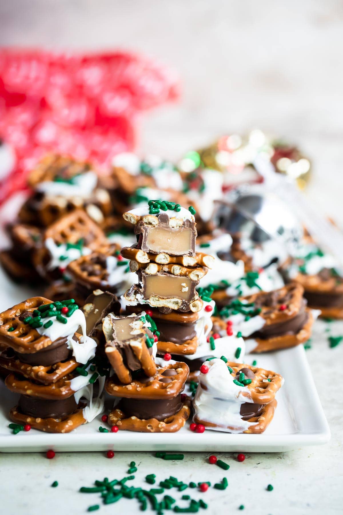 Rolo pretzel candies on a tray with Christmas sprinkles.