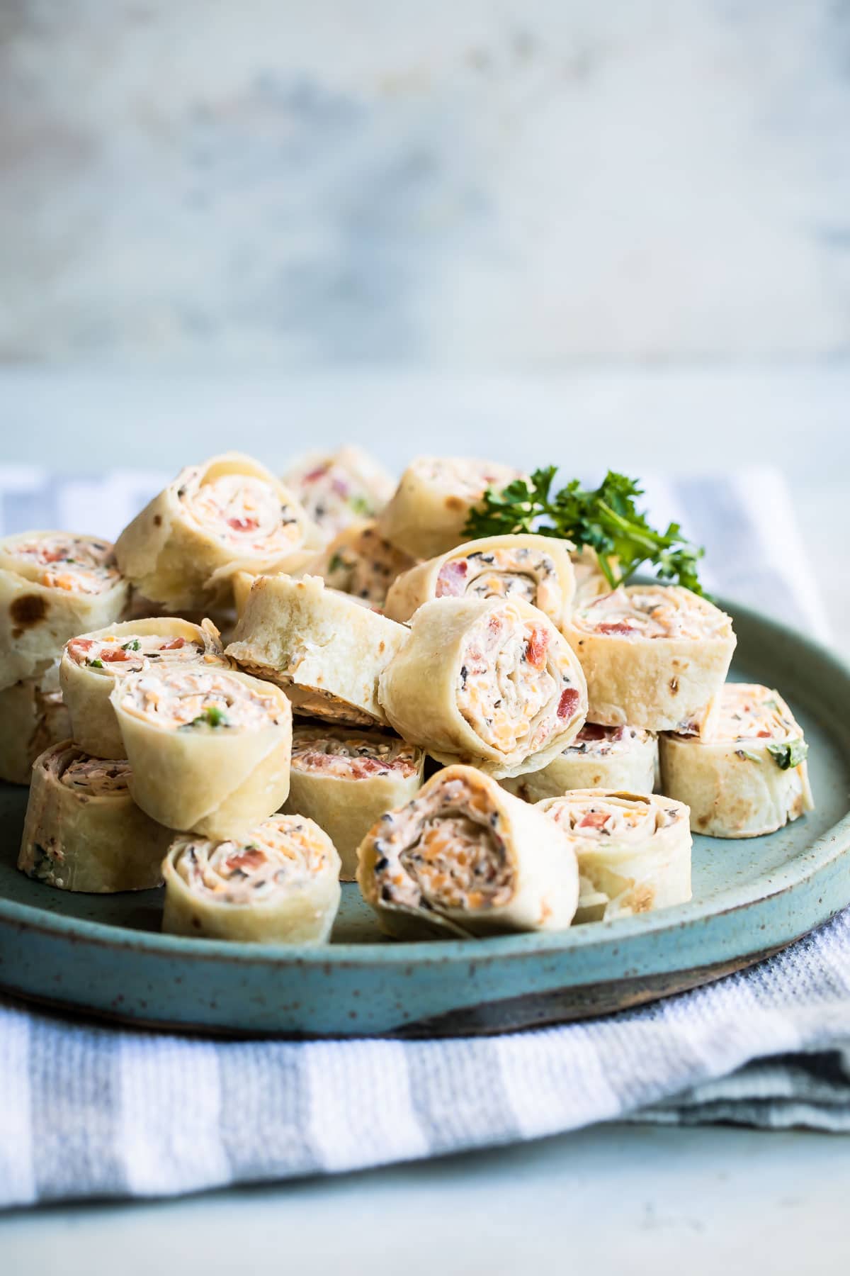 Taco tortilla roll ups on a teal platter.