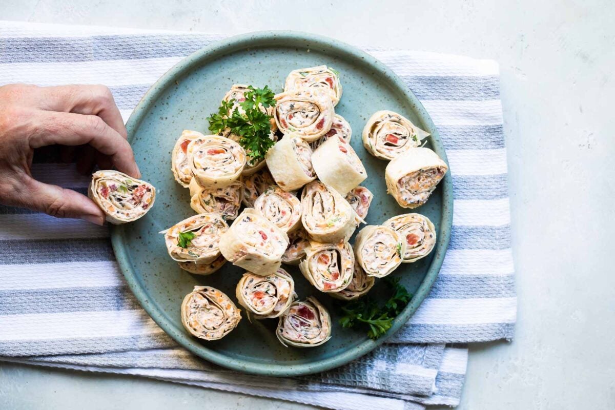 Taco tortilla roll ups on a teal platter.