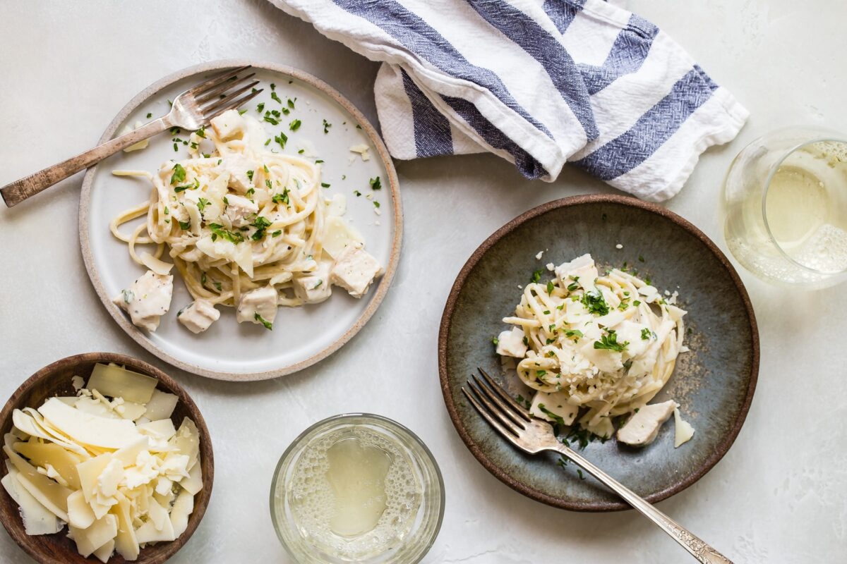 Two plates of chicken alfredo.