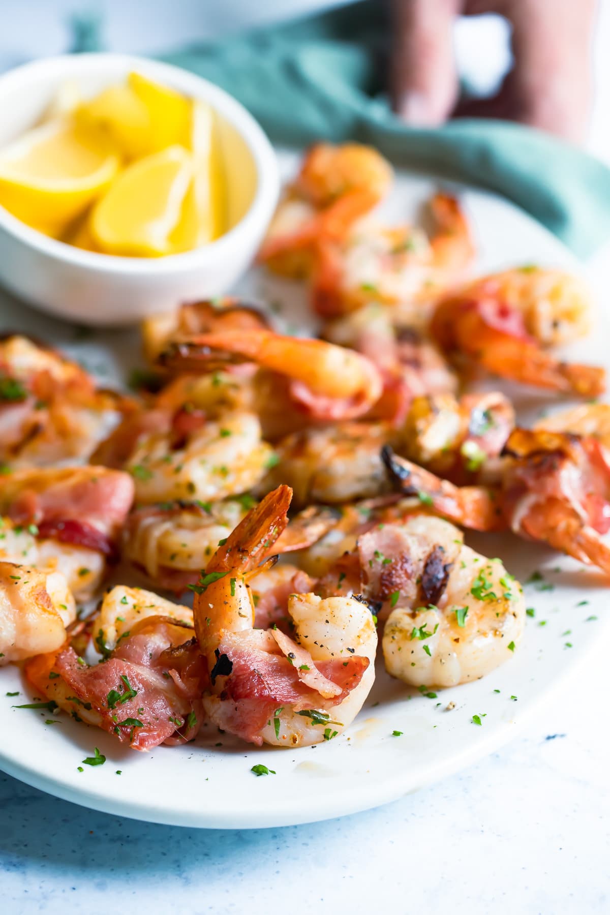 Bacon wrapped shrimp on a white serving platter.