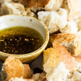 Bread Dipping oil in a small dish surrounded by bread pieces.