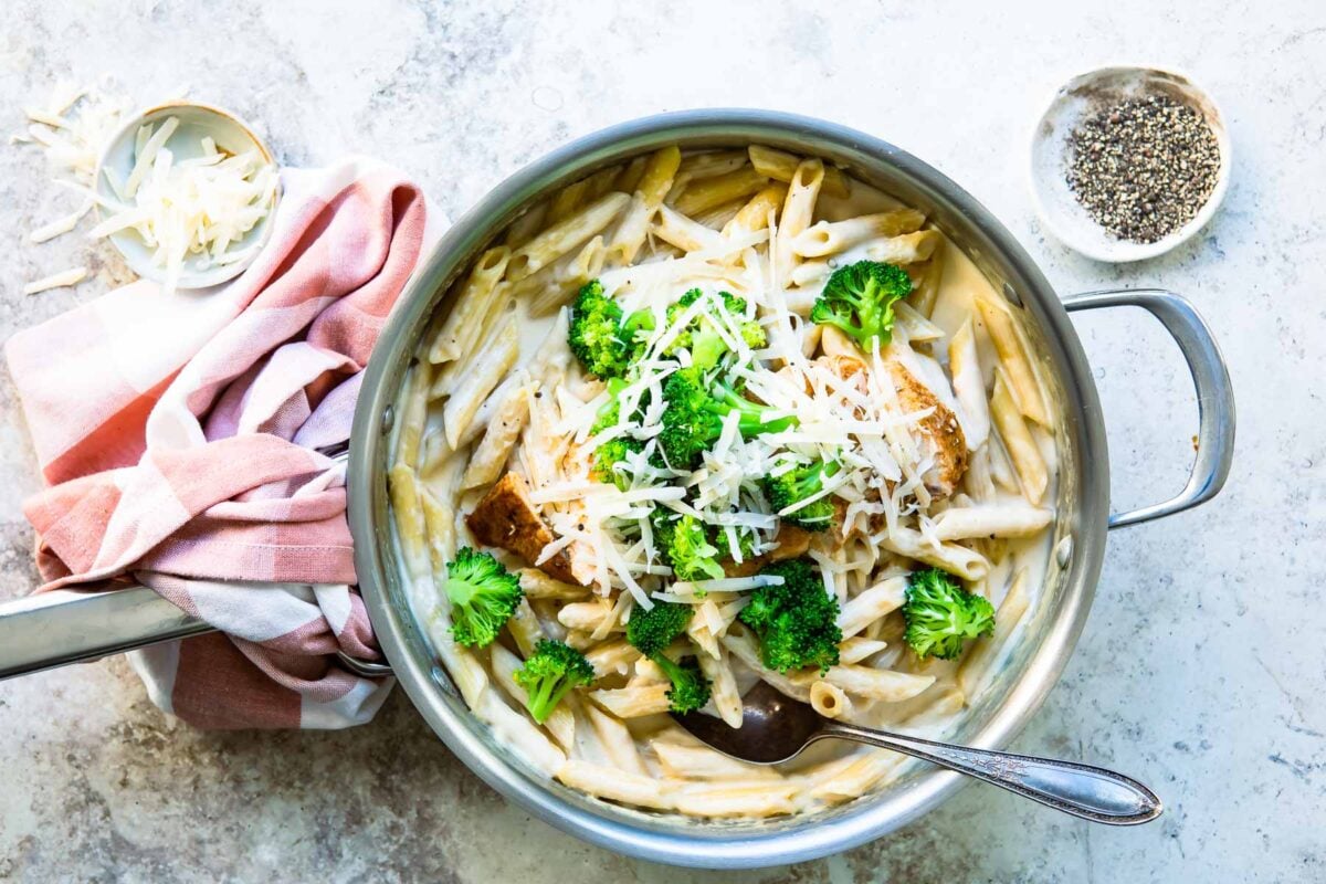 Cajun chicken alfredo with broccoli in a silver skillet.