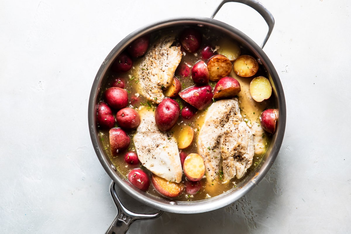 Chicken vesuvio in a silver skillet.