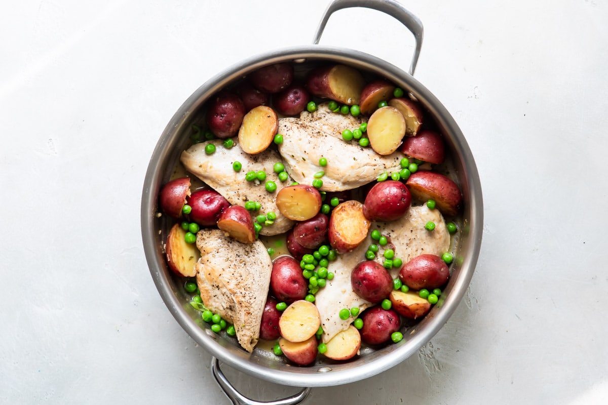 Chicken vesuvio in a silver skillet.
