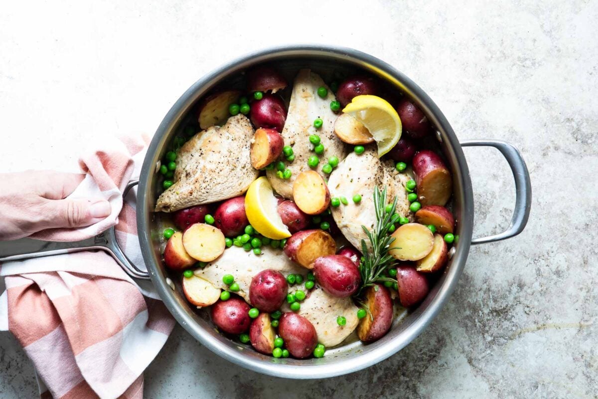 Chicken vesuvio in a silver skillet.