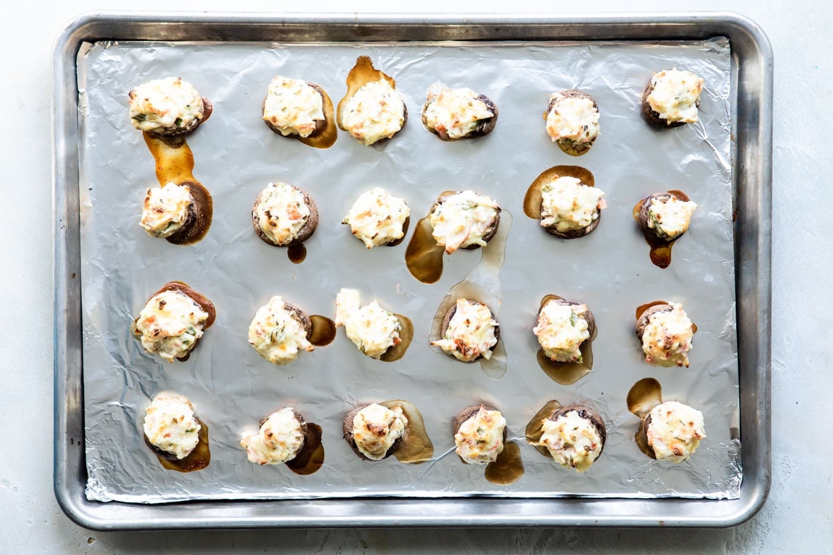 Crab stuffed mushrooms on a baking sheet after being baked.