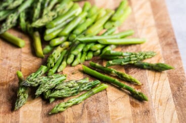 Blanched asparagus on a cutting board.