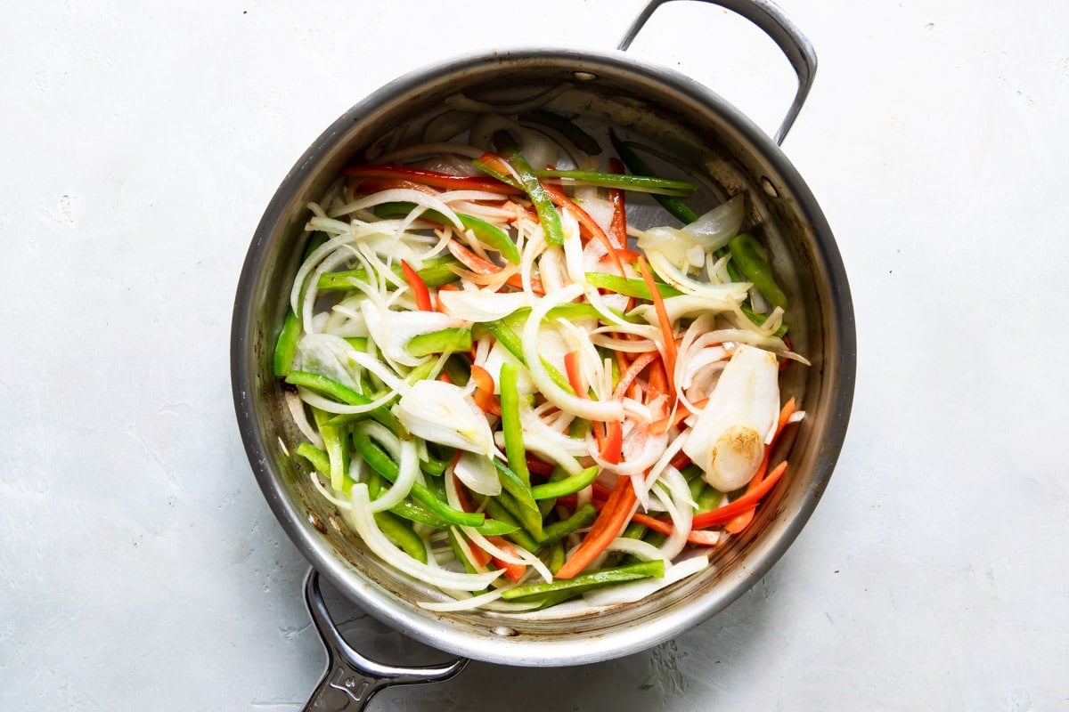 Vegetables cooking in a skillet.