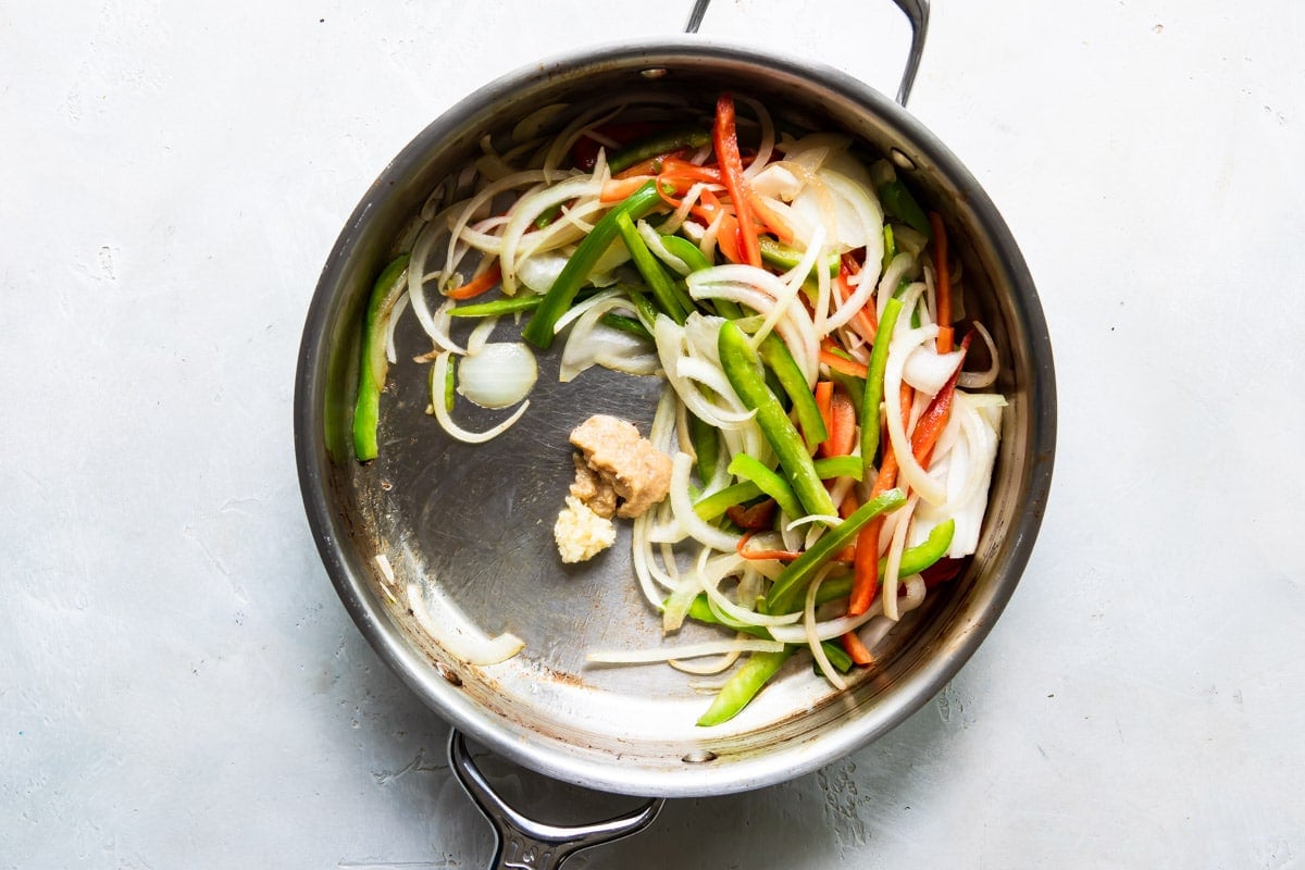 Vegetables cooking in a skillet.