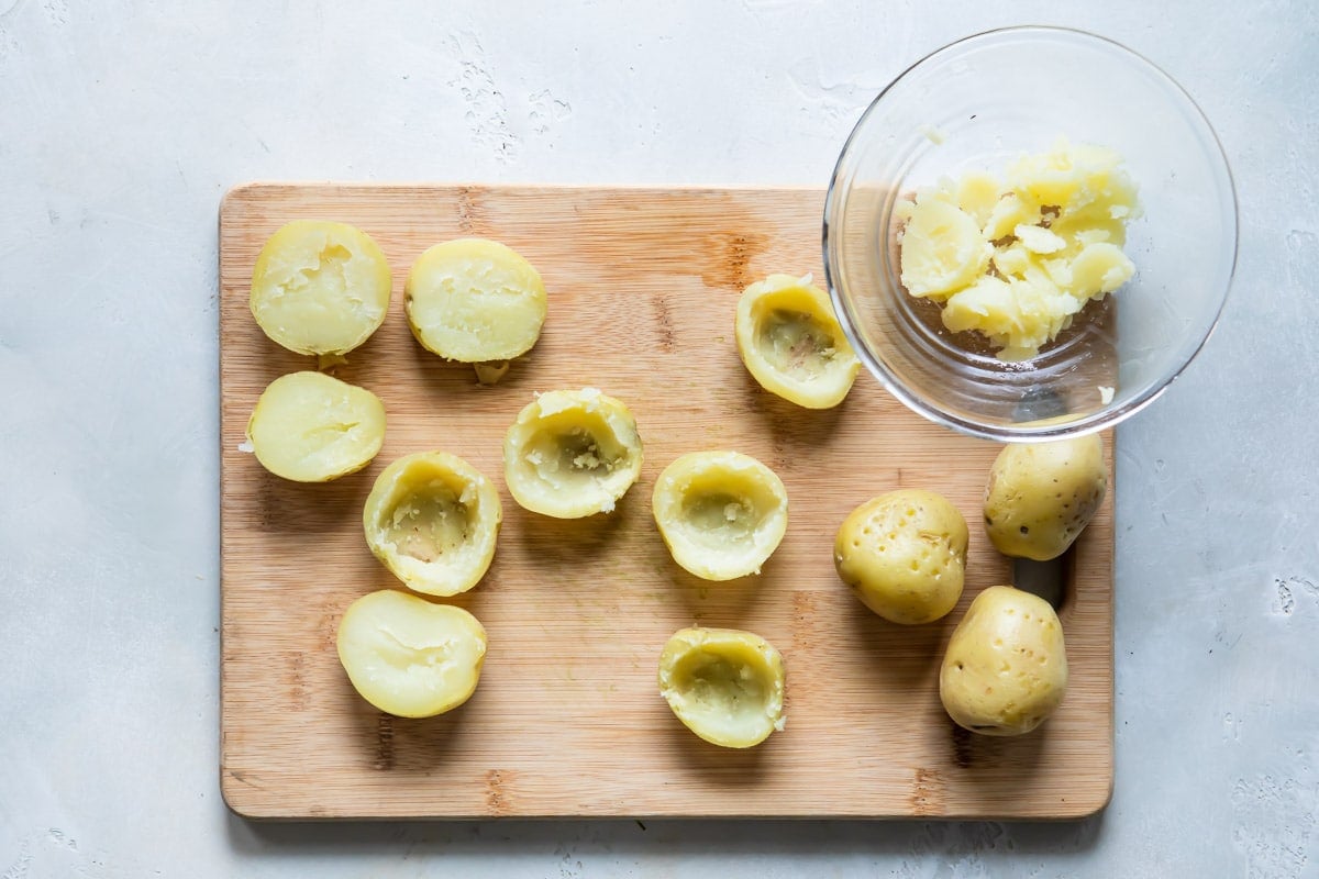 Potato being scooped out of mini potato skins.