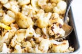 Roasted cauliflower with lemon and parmesan on a baking sheet.