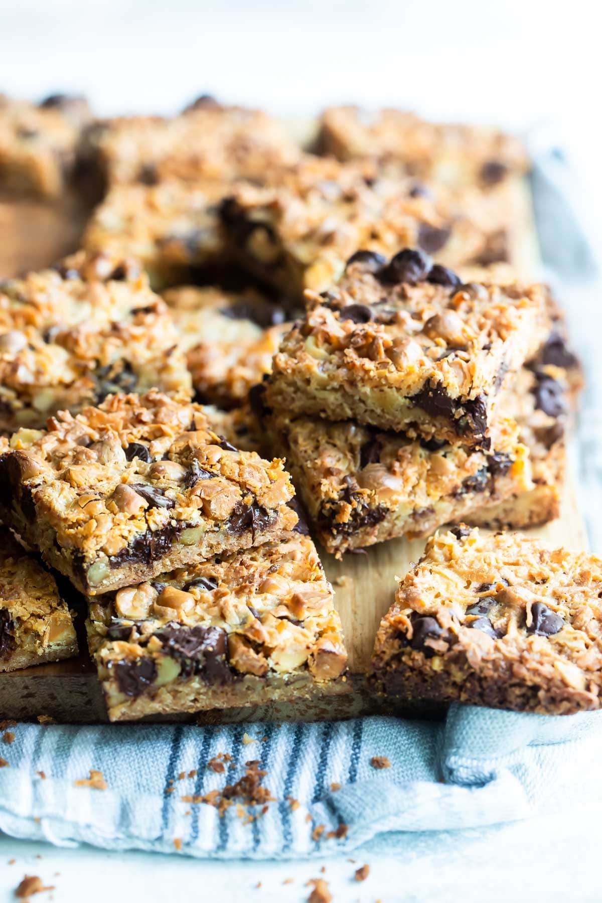Seven layer bars squares on a wooden cutting board.