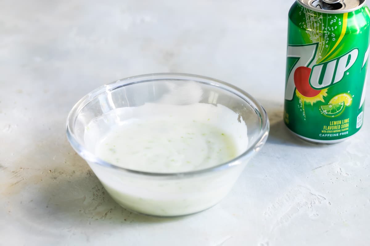 7 up cake glaze in a small clear bowl next to a can of 7 up.