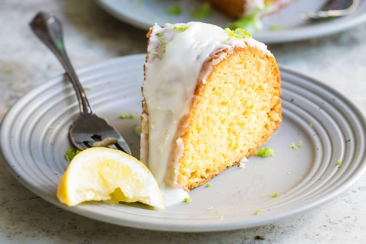 Two slices of 7 up cake on gray plates.