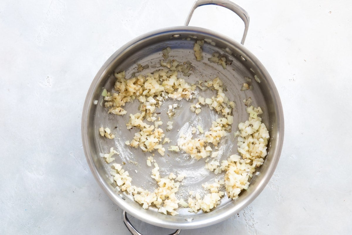 Flour, onion and butter being cooked in a saucepan.
