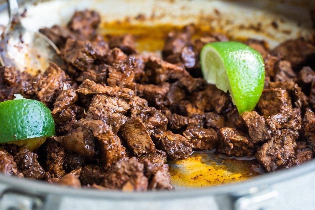 Cooking chipotle copycat steak in a skillet.
