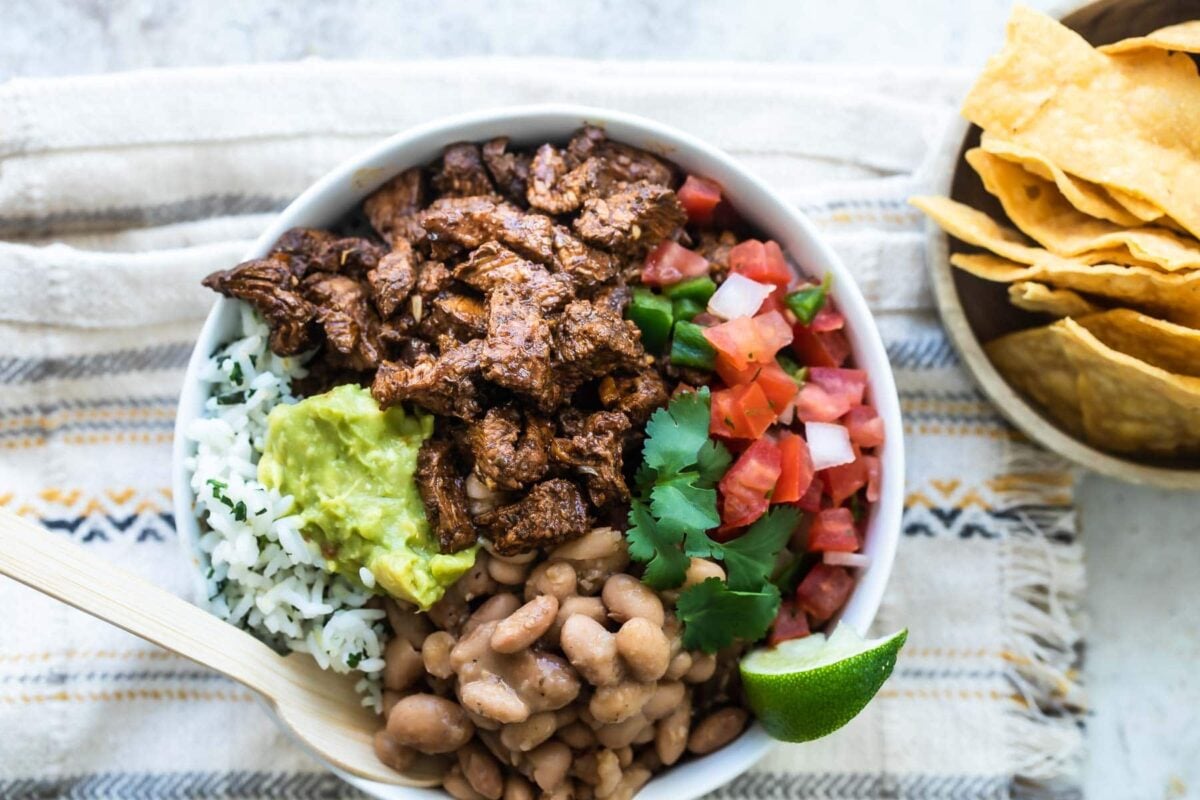 A bowl of Chipotle steak, pinto beans, cilantro-lime rice, and pico de gallo.