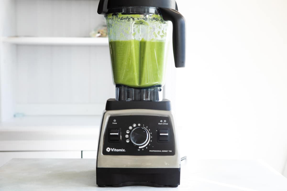 Blending cream of asparagus soup in a blender until smoothe.