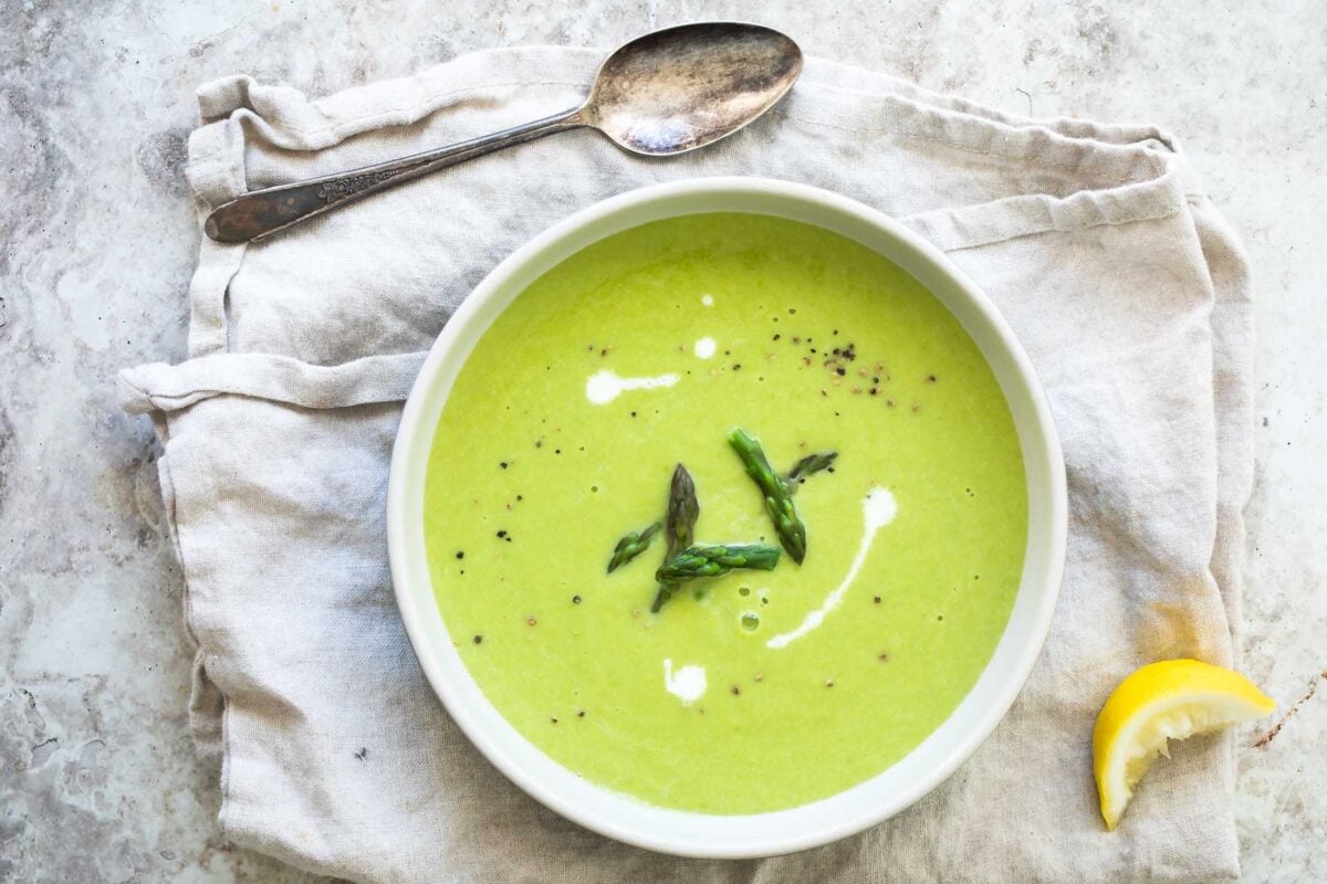 A white bowl of Cream of Asparagus Soup.