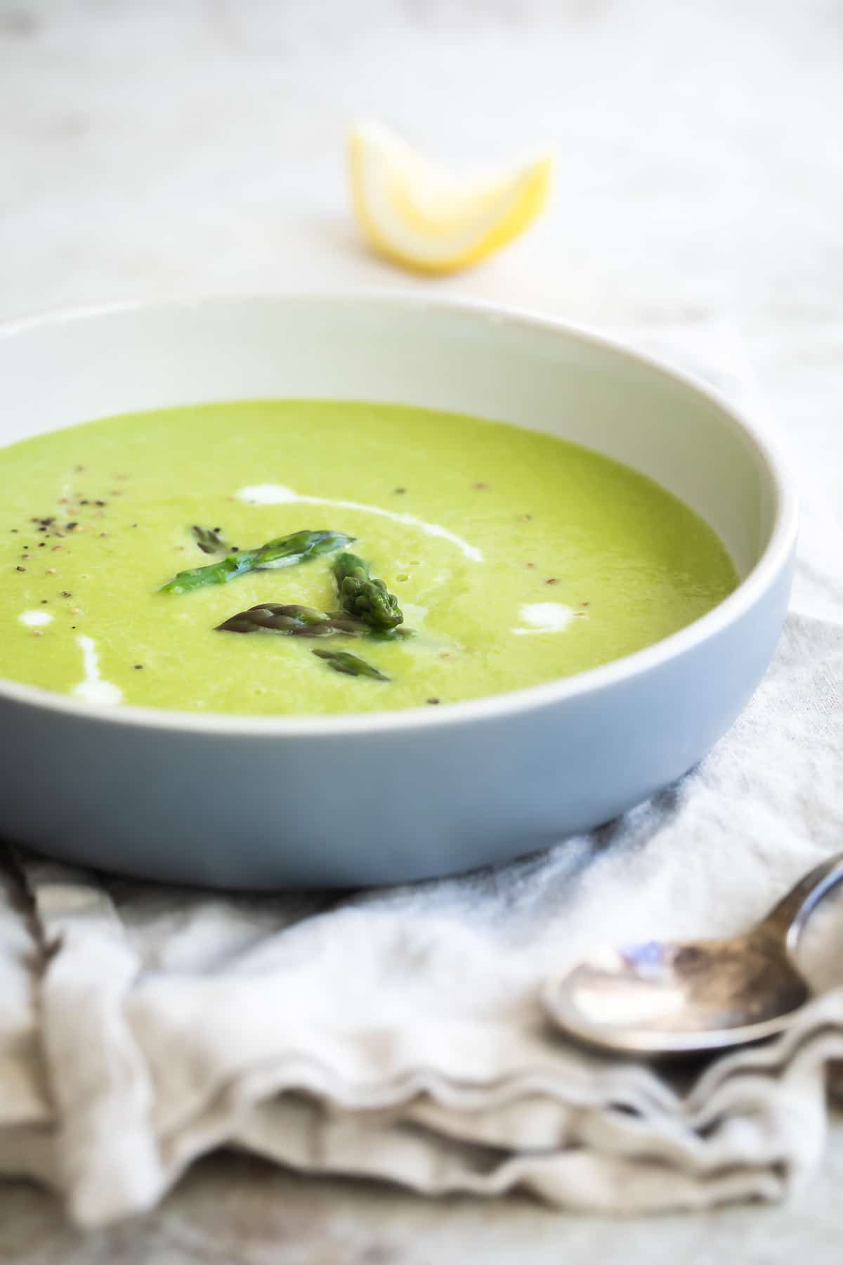 A white bowl of Cream of Asparagus Soup.