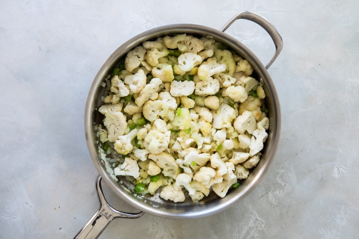 Cauliflower florets in a skillet to be steamed.