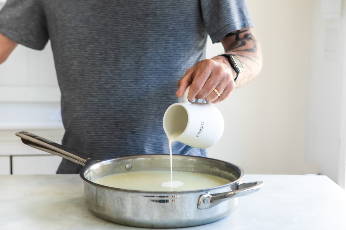 Adding cream to cream of cauliflower soup.