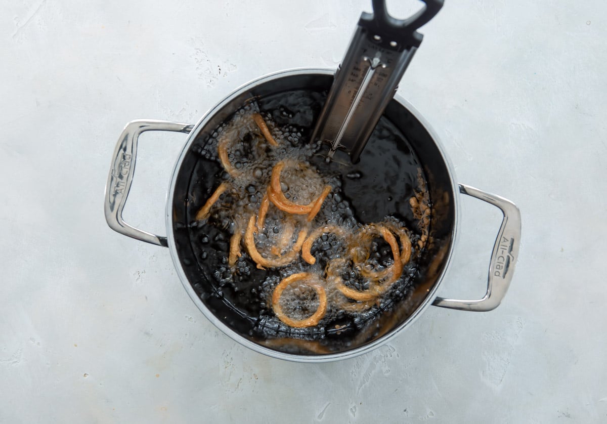 Spiralized potatoes being deep fried.