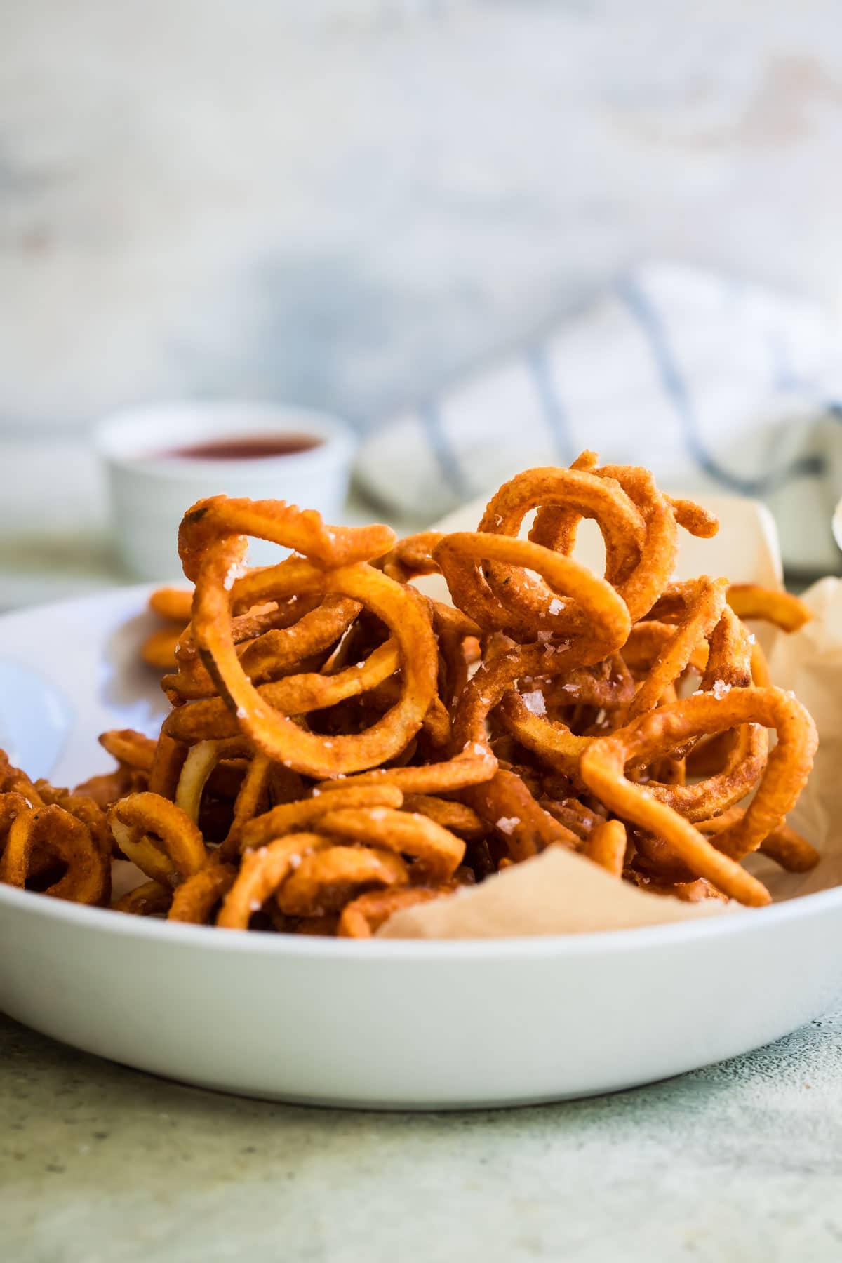 Curly fries in a white bowl.