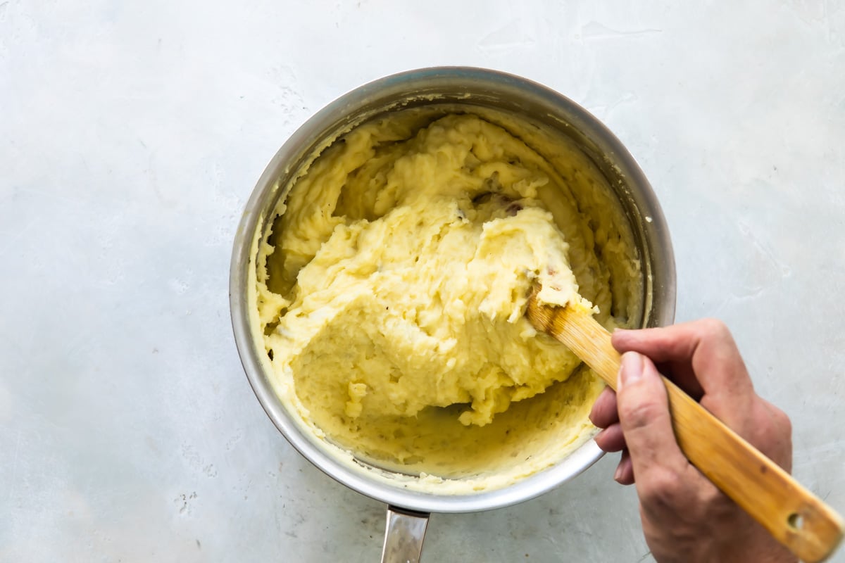 A mixing bowl with Duchess potato mixture inside.