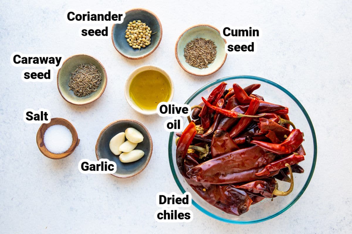 Ingredients for harissa paste in bowls, labeled.
