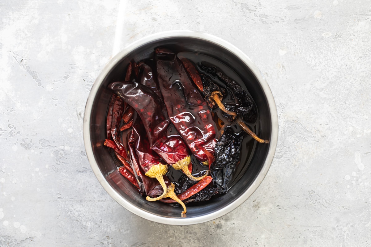 Chilies soaking in water in a silver bowl.