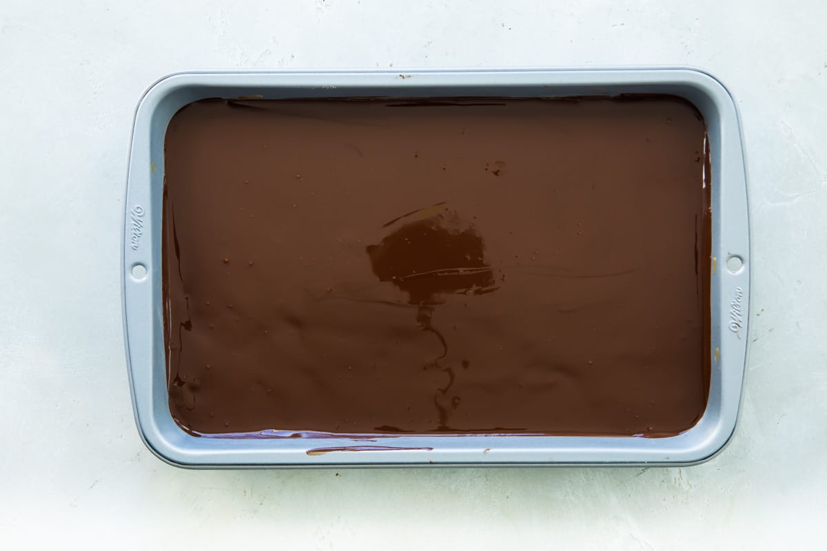 Chocolate over the chocolate layer of homemade Snickers bars.