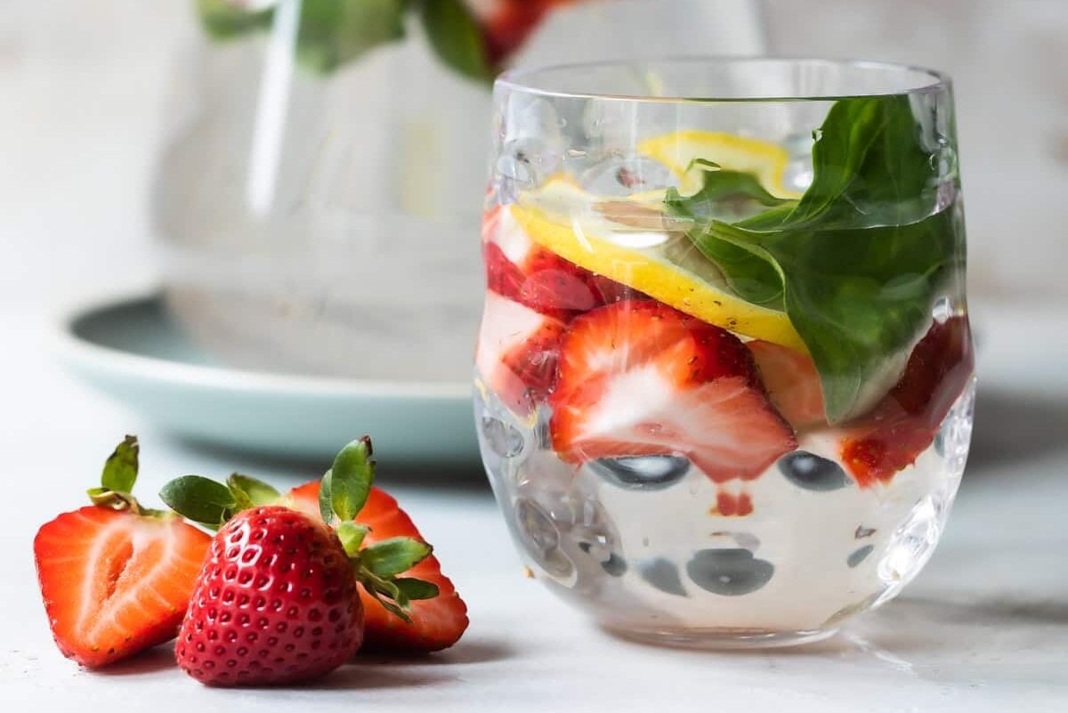 Glasses of water infused with fruit, vegetables, and fresh herbs.
