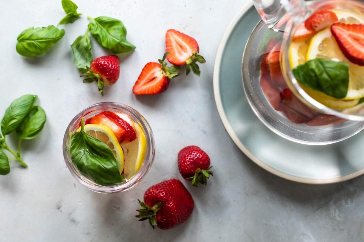 Glasses of water infused with fruit, vegetables, and fresh herbs.