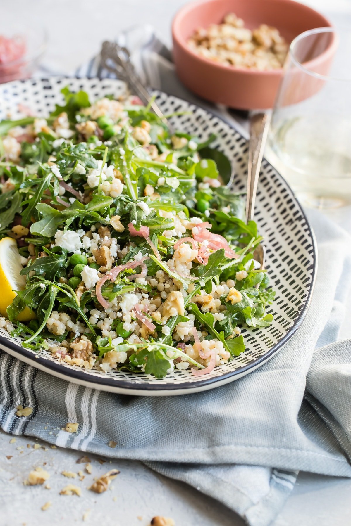Israeli Couscous salad on a white and black platter.