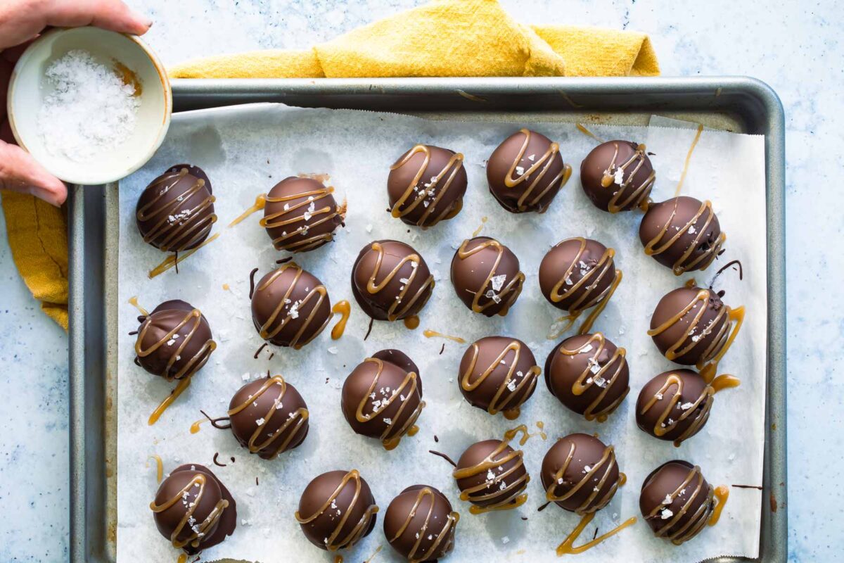 Oreo cookie balls on a parchment paper lined baking sheet.
