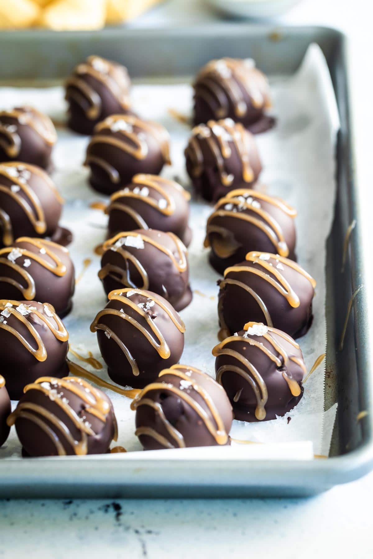 Oreo cookie balls on a parchment paper lined baking sheet.