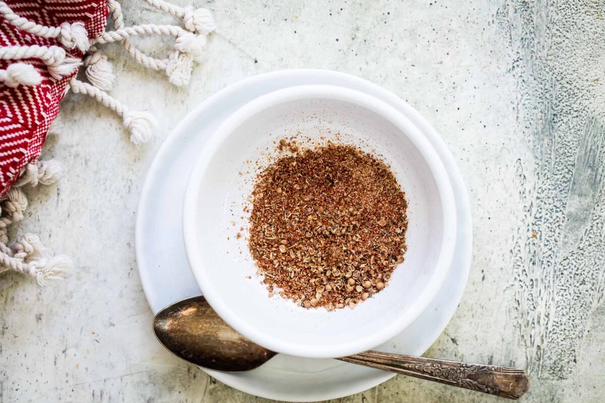 Seasoning for pork burgers in a small white bowl.