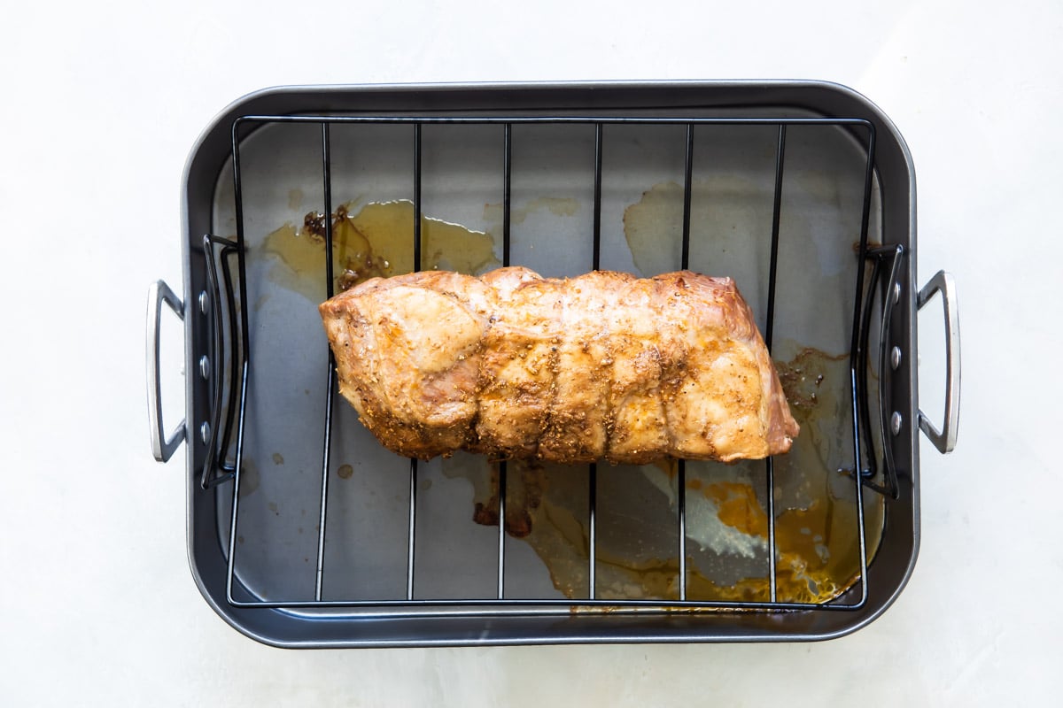 A pork roast in on a roasting rack.