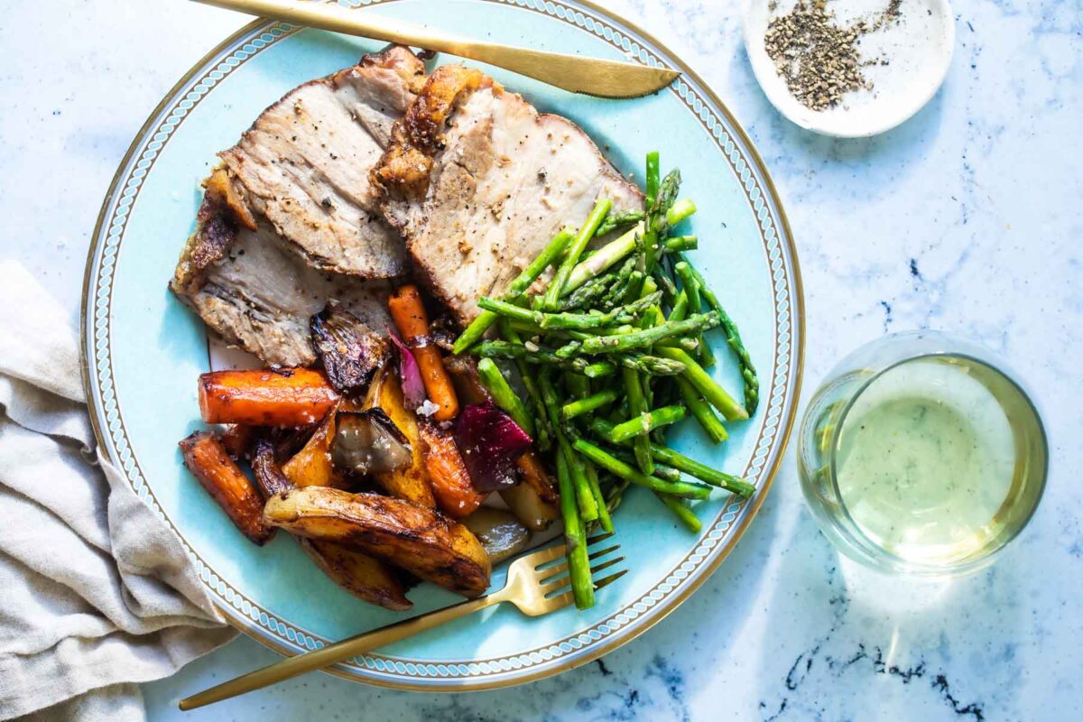 Pork roast, asparagus and vegetables on a plate.