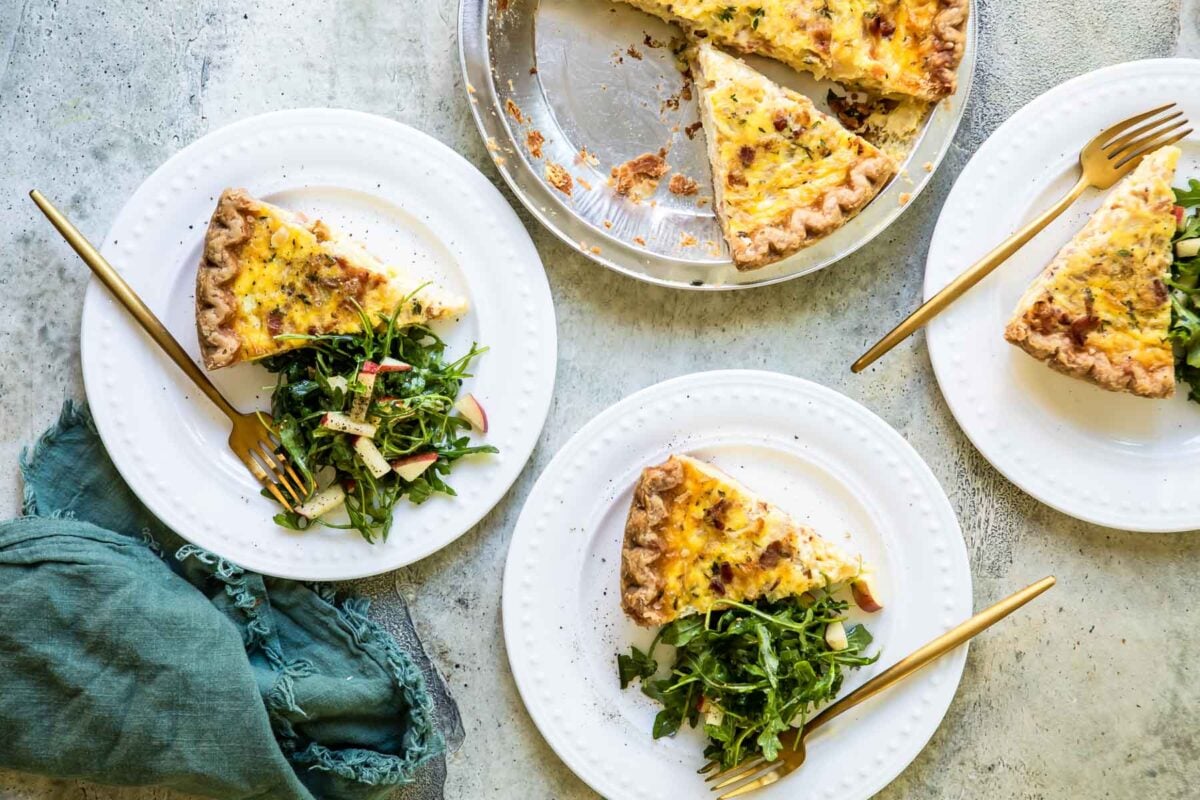 Three slices of quiche Lorraine on plates.