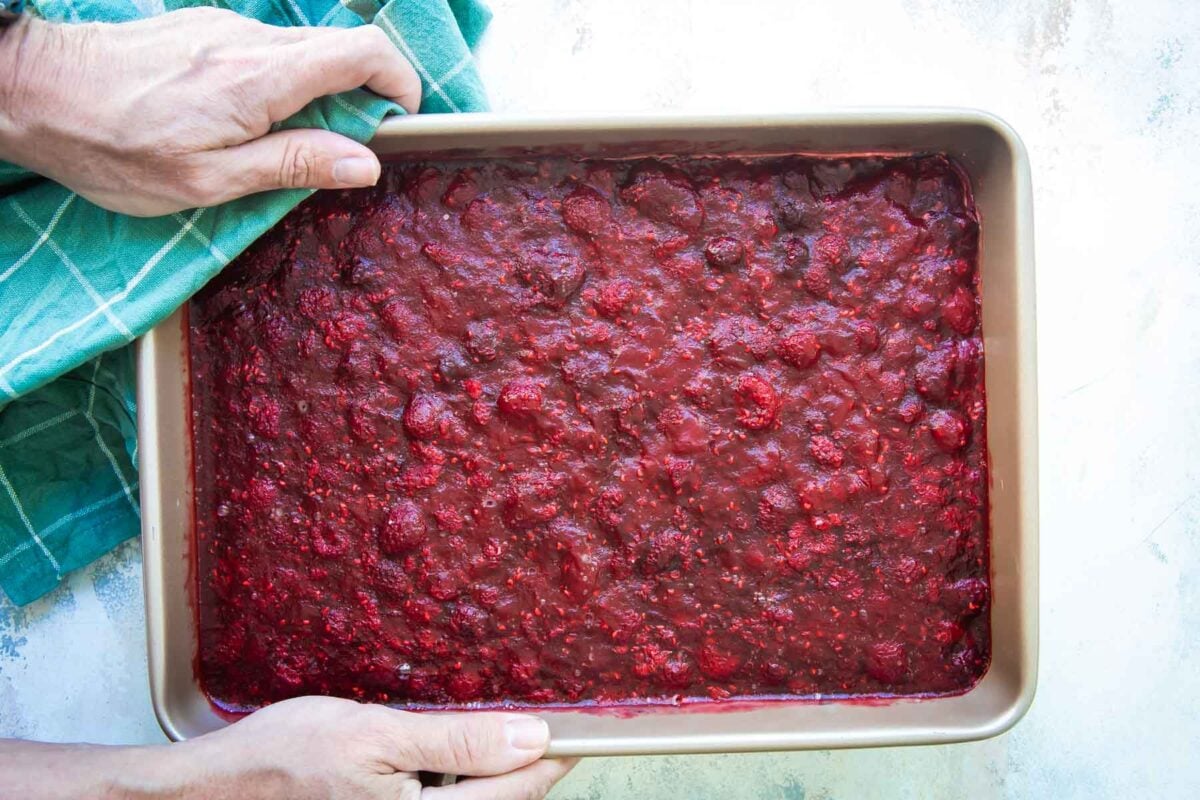 A pan with raspberry pretzel jello salad in it.