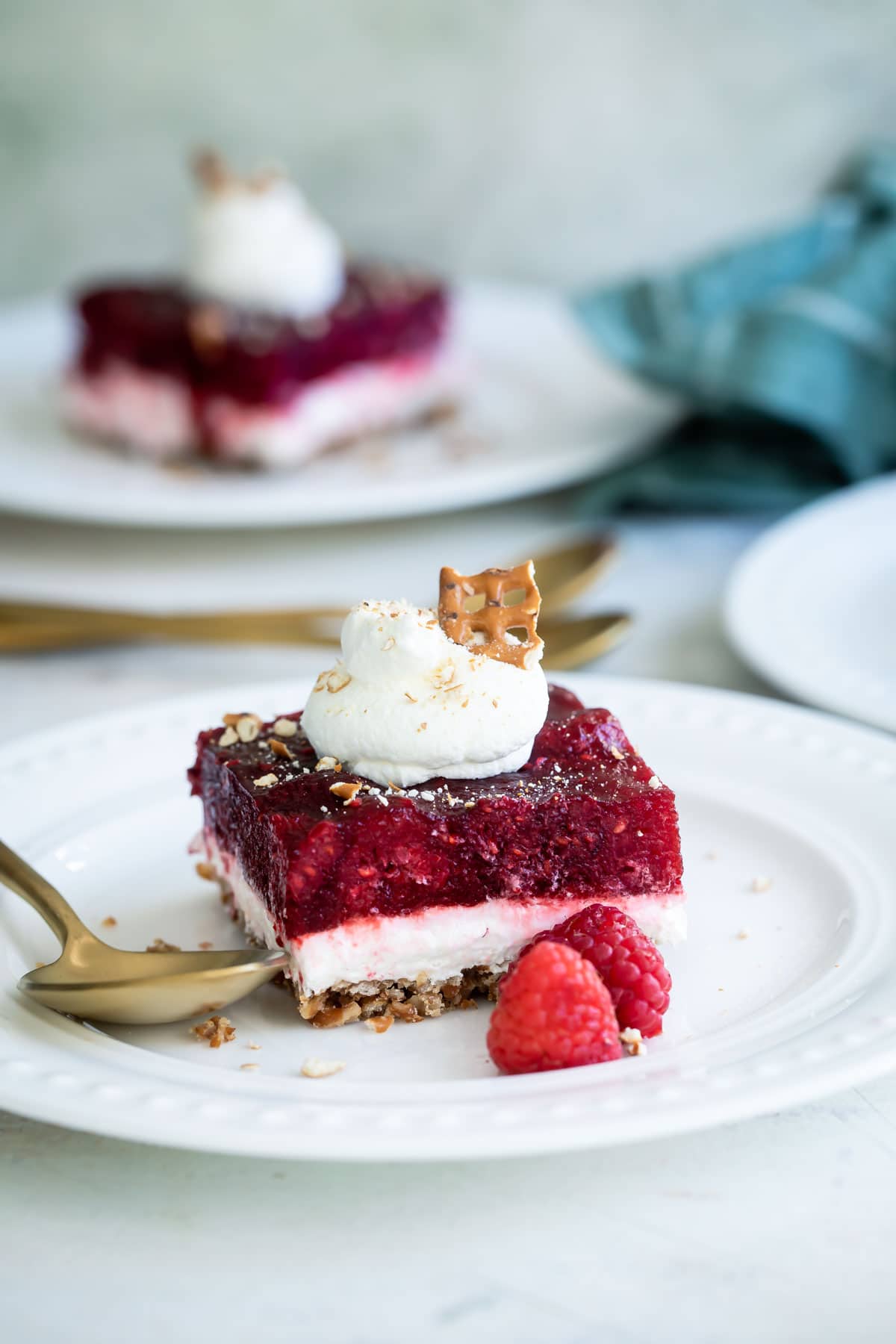 A slice of raspberry pretzel jello salad on a white plate.