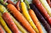 Roasted carrots on a parchment paper lined baking sheet.