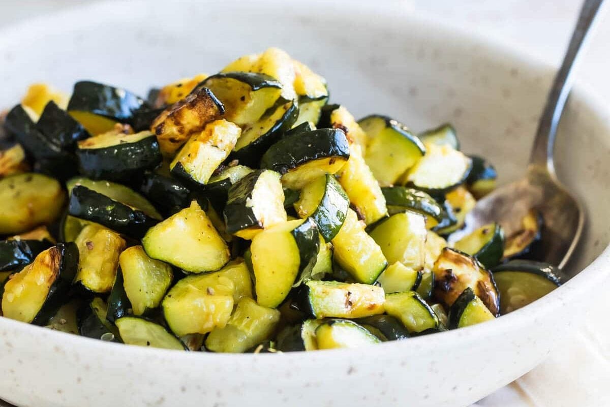 Roasted zucchini in a gray speckled bowl.