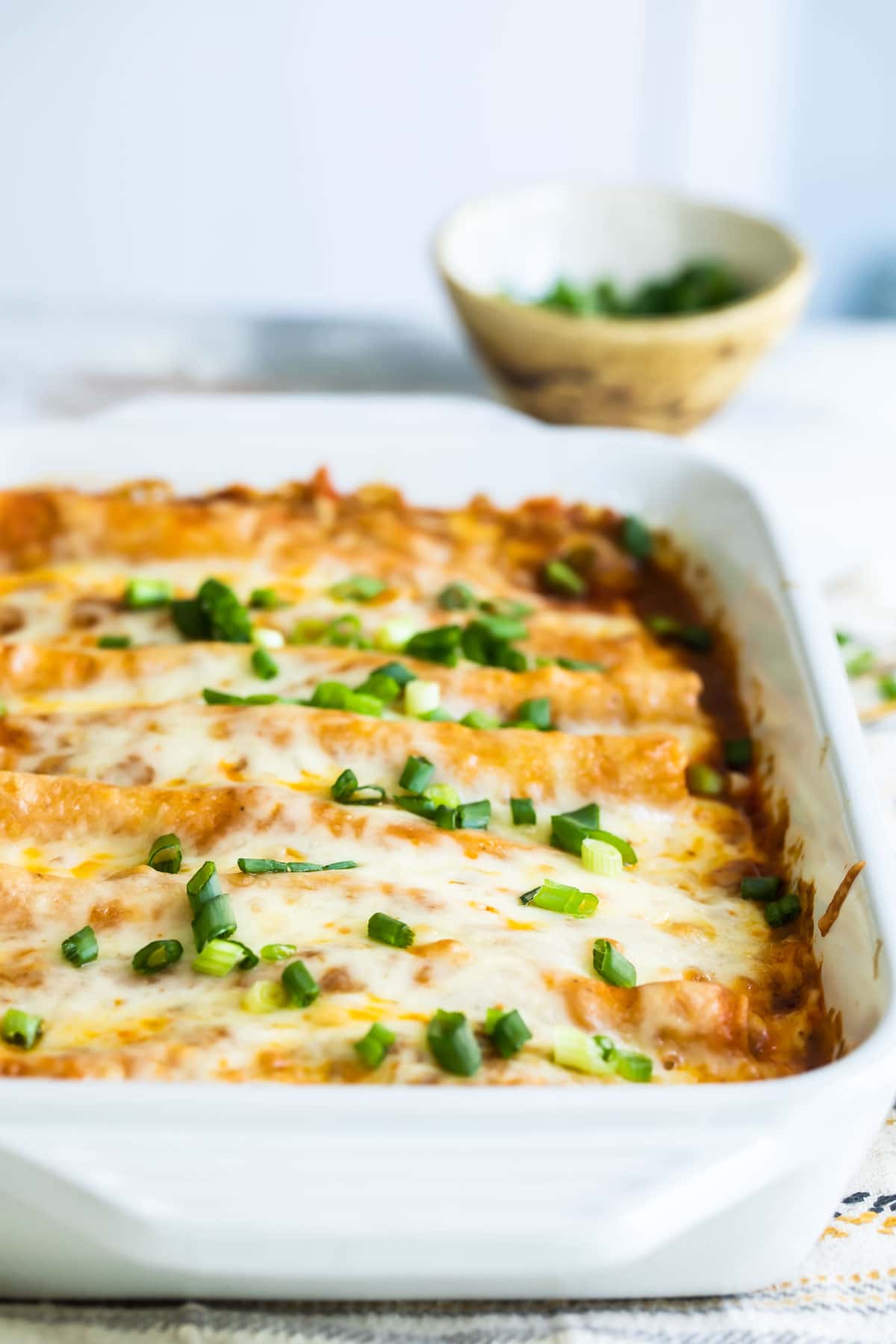 A casserole dish with chicken enchiladas.